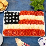 American Flag Caprese Salad with tomatoes, mozzarella, blueberries, and basil on a serving platter