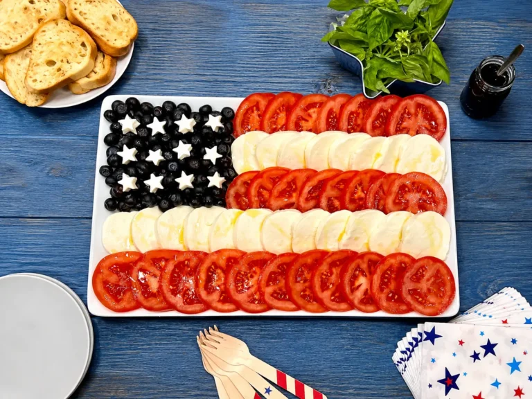 American Flag Caprese Salad with tomatoes, mozzarella, blueberries, and basil on a serving platter