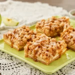 Caramel Apple Cheesecake topped with apple pie filling, caramel sauce, and crunchy pecans
