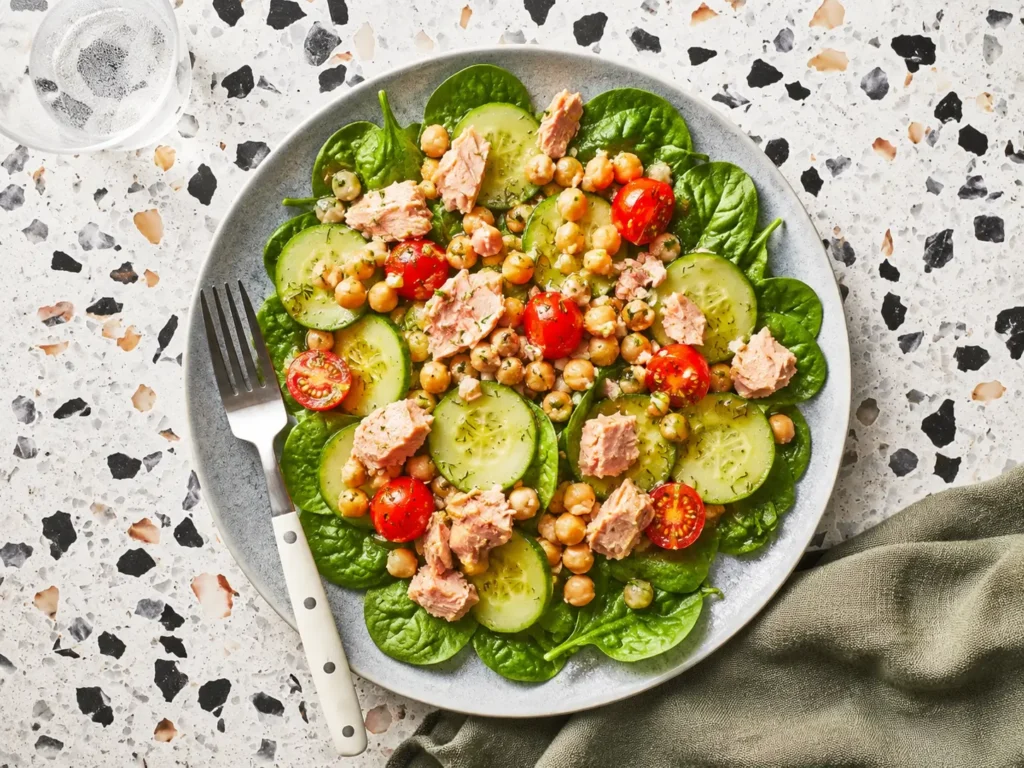 Chickpea Tuna Salad with feta, cucumber, tomatoes, and fresh dill in a serving bowl