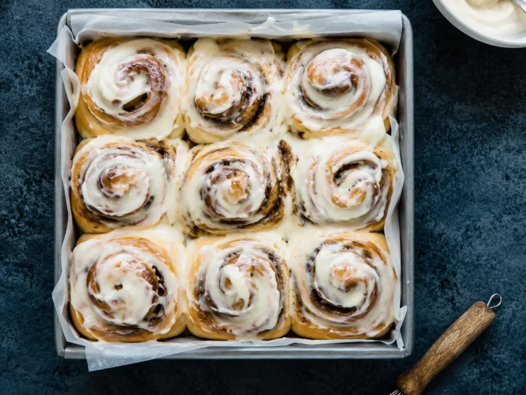 Freshly baked Cinnamon Rolls with cream cheese icing in a baking pan