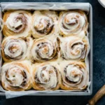 Freshly baked Cinnamon Rolls with cream cheese icing in a baking pan