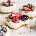 Frozen Yogurt Granola Cups topped with fresh berries in a muffin tray