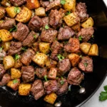 Garlic Butter Steak Bites and Potatoes served in a cast iron skillet