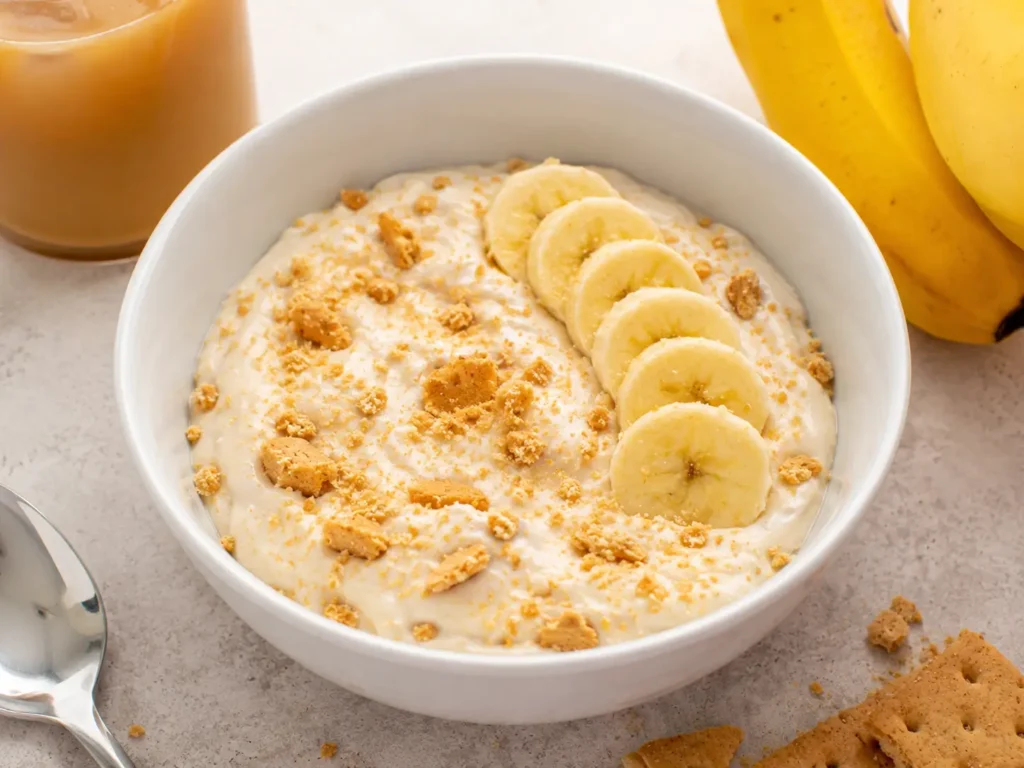 Creamy Greek Yogurt Banana Pudding topped with banana slices and graham cracker crumbs