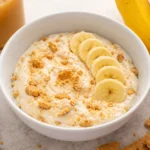 Creamy Greek Yogurt Banana Pudding topped with banana slices and graham cracker crumbs