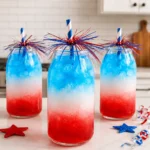 July 4th Layered Drinks Recipe served in clear glasses with red white and blue layers