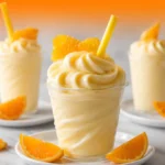 Creamy homemade Orange Dole Whip served in a chilled dessert glass