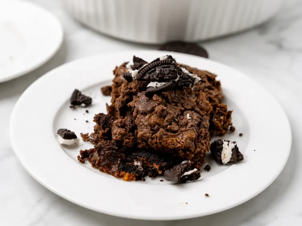 Warm Oreo Dump Cake topped with whipped cream and crushed cookies