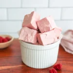 Soft homemade Raspberry Marshmallows stacked on a plate with fresh raspberries