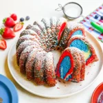 Red White & Blue Marble Cake sliced on a cake stand with bright patriotic swirls