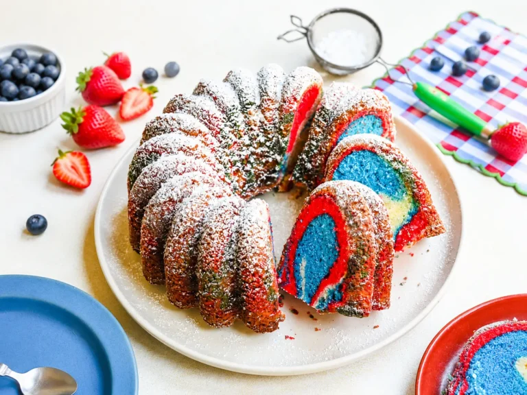 Red White & Blue Marble Cake sliced on a cake stand with bright patriotic swirls