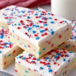 Soft frosted Sugar Cookie Bars with patriotic sprinkles on a dessert tray