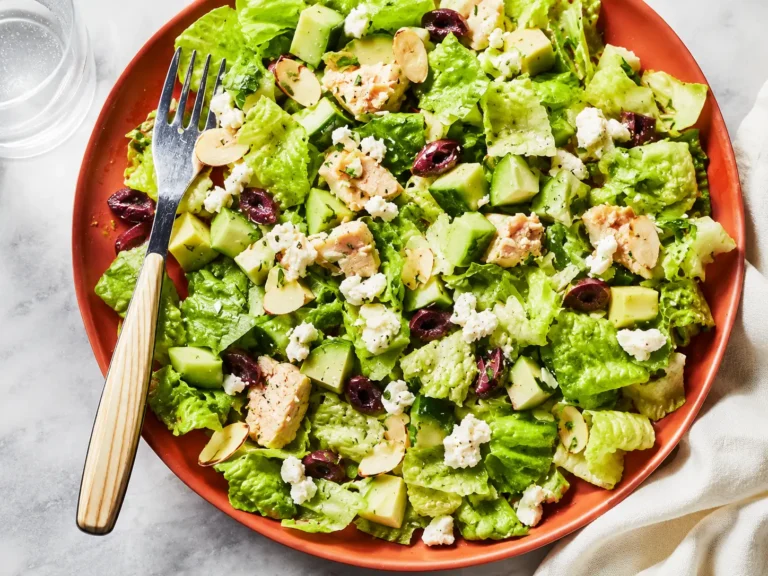 Avocado Tuna Salad served in a bowl with feta, cucumber, olives, and toasted almonds