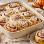 Pumpkin Cinnamon Rolls prepared and styled for serving on a neutral kitchen table